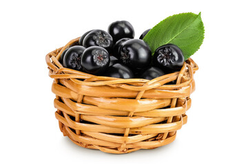 Chokeberry with leaf in a wicker basket isolated on white background. Black aronia.