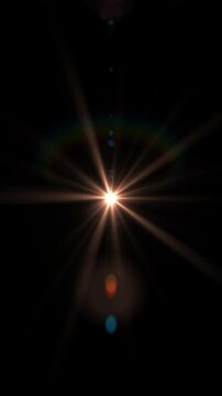 A bright spikeball light source creating a starbust effect with colorful bokeh lights, rainbow iris and hoop effects. Animated background. Seamless loop. Vertical.