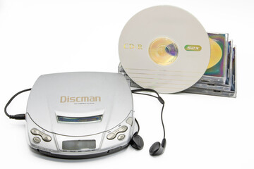 Close-up of a discman with cd cases next to it isolated on white background