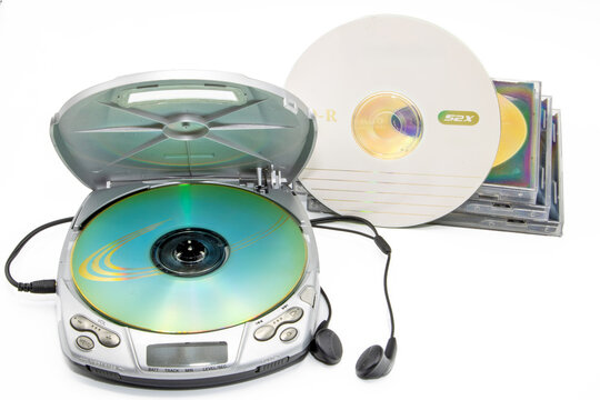 Close-up of a discman with cd cases next to it isolated on white background