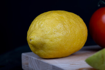 ripe yellow lemon on a cutting board in the kitchen