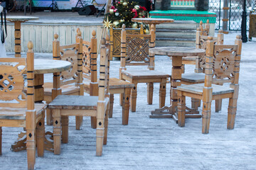Wooden chairs with tables in the snow. Winter New Year's Eve porch