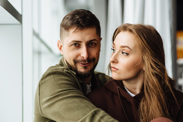 Portrait of a beautiful young couple. Close-up of a woman looking at a man in disbelief. Photo of a cheerful young adult boy and a sad girl. Concept of problems in relationships, family.