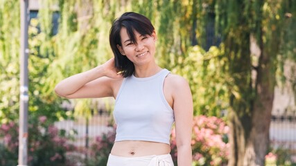 Smiling Asian woman looking at camera in city park