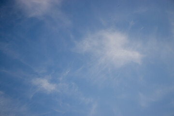 Obraz premium Blue sky with light clouds on a clear day. Perfect serene backdrop for nature or outdoor-themed content. Ideal for backgrounds or textures.