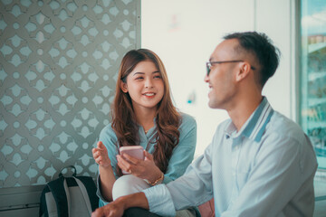 In a modern cafe ambiance, a friendly dialogue unfolds between two individuals who are nearby