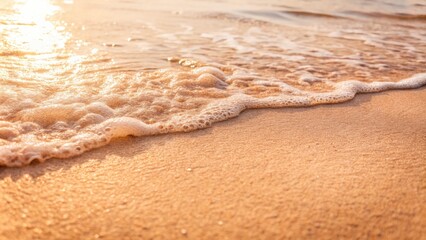 Gentle ocean wave laps against a sandy beach.