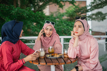 Three friends chatting and sipping drinks in a vibrant caf setting