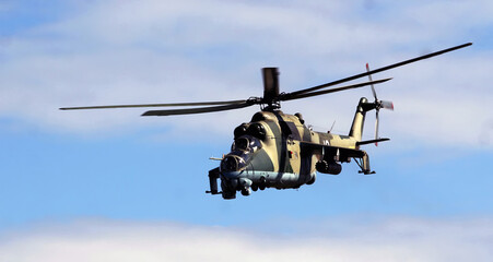 Military helicopter flying against a clear blue sky during a training exercise, showcasing maneuverability and precision in action