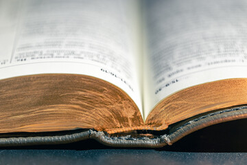 Open Bible on a black background. Religion concept. Bible pages close-up.