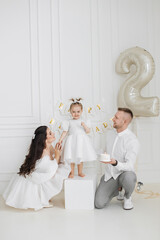 Caucasian family celebrating young girl's second birthday. Parents with two-year-old daughter in...