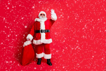 Full length body size view of his he cheerful funky fat overweight plump gray-haired bearded man carrying purchases waving greetings congrats tradition isolated over bright vivid shine red background