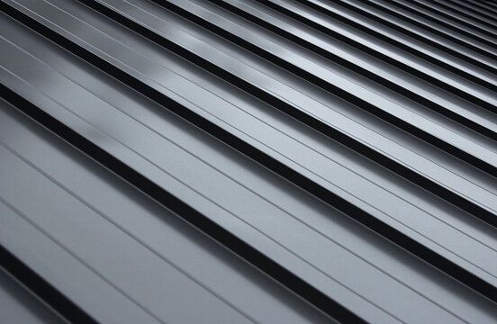 Close-up house retro roof panel with standing seam and fasteners. Modern galvanized steel roofing sheet with ribs. Classic style black metal panel with rebate joint. Falz roofing. Building's covering