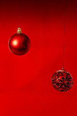 Red Christmas tree baubles against a matching red background, creating a festive, minimalist holiday theme with vibrant color and elegant simplicity.