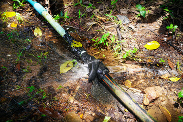 Black polyethylene pipe connect with blue pvc pipe leakage and repair by black tape laying on the...
