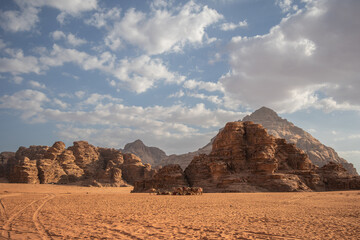 Jordanian Scenery of Wadi Rum Desert with Group of Camels. Rock Formations with Sandy Ground Outdoors in Southern Jordan. Beautiful Landscape in the Middle East during Sunny Day.