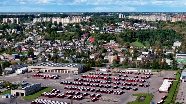 Aerial 4K video footage of a bus park with many electricity and gasoline powered buses in Kaunas, Lithuania. Public transport