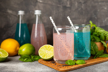 Diet detox cocktail with basil and chia seeds in a glass jar and a glass on a textured background....