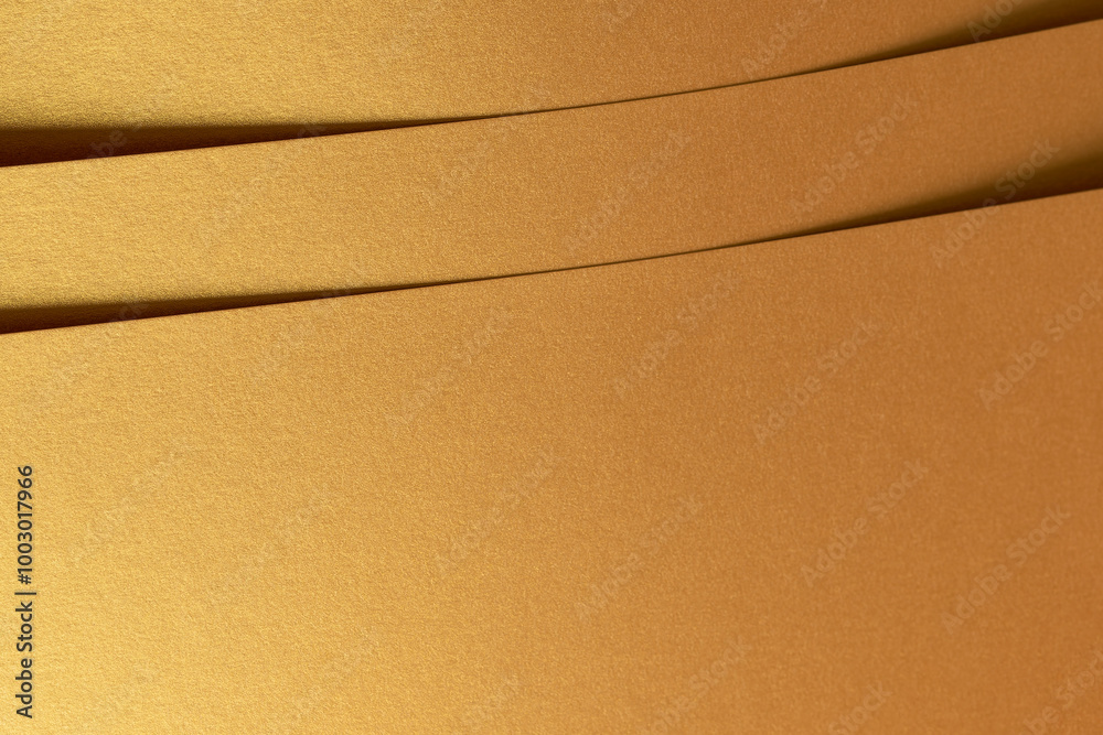 Poster Golden metallic paper with a layered texture and shiny surface in brass and yellow tones. The minimalist design features rich folds and geometric lines, creating an elegant and