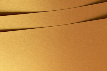 Golden metallic paper with a layered texture and shiny surface in brass and yellow tones. The...