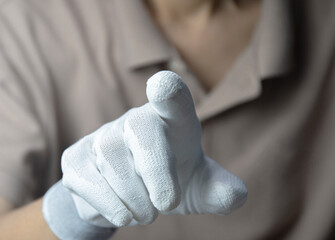 Man wearing white gloves, pointing finger