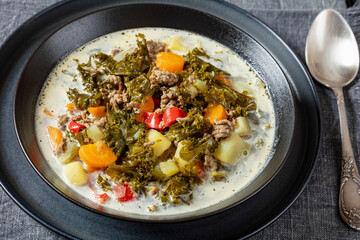 ground beef veggies kale soup in black bowl