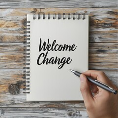 Welcome change hand lettering in notebook with pen on wooden background.