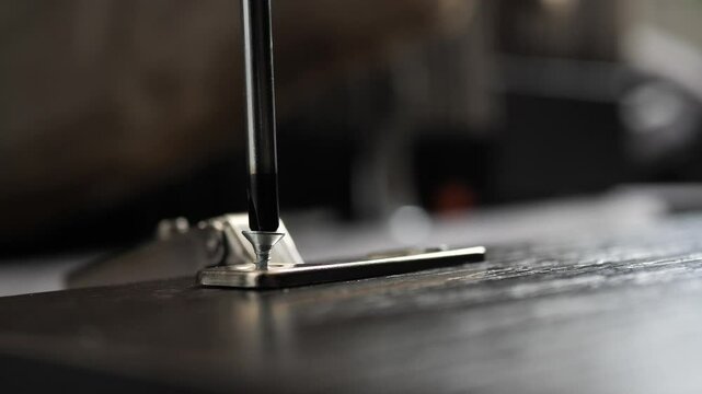 Installing hinges on a furniture door using a Phillips screwdriver. furniture assembly.