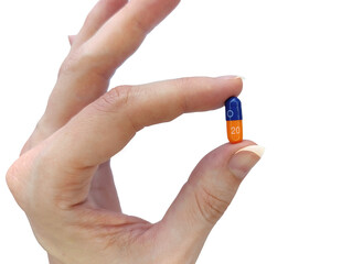 Capsule tablet medicine in a woman's hand, two-color capsule