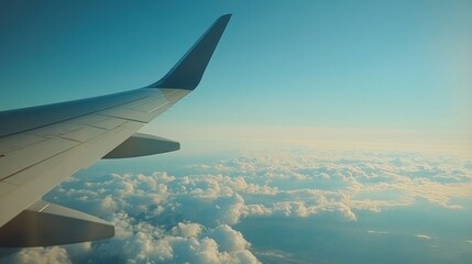 Obraz premium Aerial view from an airplane window showcasing clouds and blue sky.