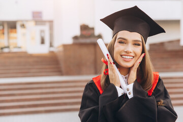 Smiling Female Graduate Celebrating Achievement in Cap and Gown at University Ceremony