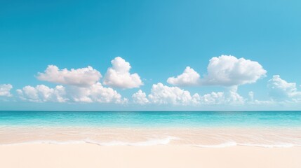 Obraz premium A clear blue sky with fluffy white clouds, casting gentle shadows on a sandy beach and a turquoise ocean.