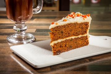 Moist Carrot Cake with Cream Cheese Frosting with Hot Chocolate Coffee mug served in tray dish isolated on table side view of cafe baked dessert food
