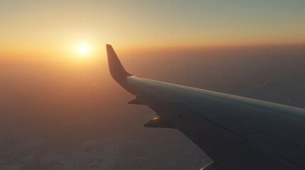 Obraz premium Aerial view of an airplane wing with a sunset in the background.