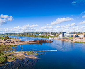 Obraz premium Construction site of new modern bridge construction in Kaunas, Lithuania. Aerial drone view of bridge connecting two shores of a river. Work progress
