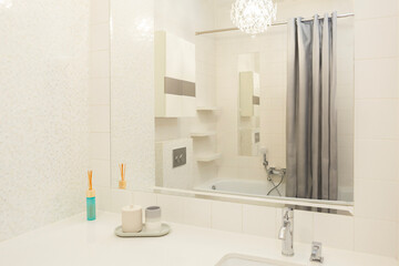 A white bathroom in an apartment with a light interior