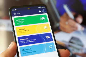 Carteira digital de transito na tela de um celular com fundo desfocado.