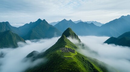 Aerial view of Machu Picchu surrounded by steep green mountains with mist rolling through the valley 