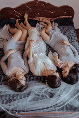 A woman is getting ready for a wedding and is putting on her jewelry. The mirror reflects her as she does so