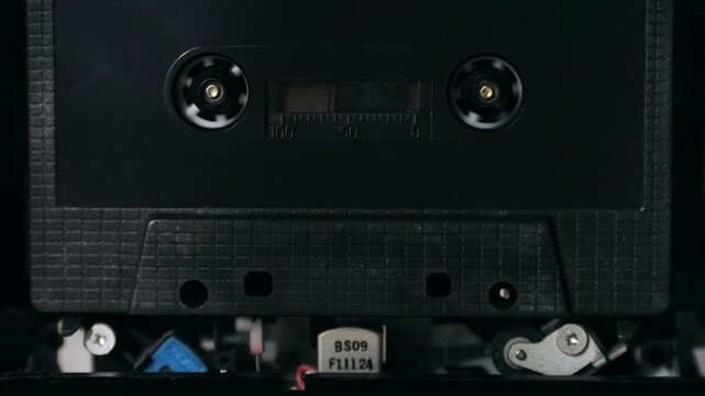 Retro radio tape recorder, audio cassette close-up. Listening to music, old radio boom box player, macro of vintage music listening. 