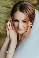 Naklejka premium A woman wearing a wedding dress and a pearl bracelet. She is smiling and looking at the camera