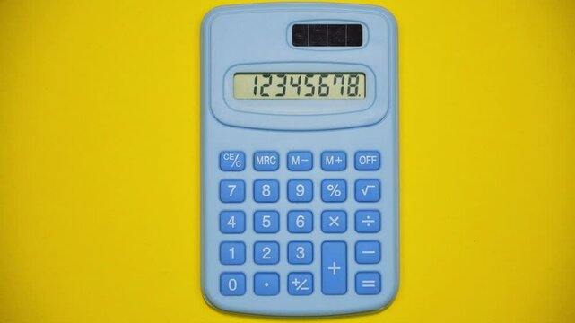 Blue calculator on yellow background. Stop motion animation
