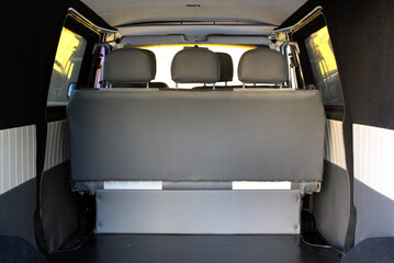 Row of passenger seats of passenger van rear view. Ceiling of old passenger van. Ceiling van. Car ceiling. Passenger van interior. View from bottom to top. Clean trunk of minivan.