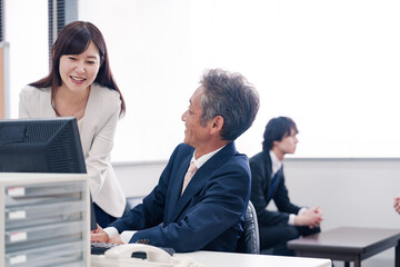 オフィスで上司に報告をするビジネスウーマン