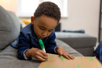 Joyful kid using marker to draw feeling the fun of art