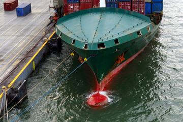 Green container vessel with completely covered of forward mooring station moored in Kingston, Jamaica. 
