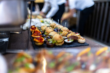 Delicious assortment of gourmet appetizers displayed on a black platter at an elegant event