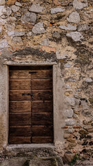 Entrance to an old stone house. Dark brown wood, stone stairs, rusted iron and natural stone.