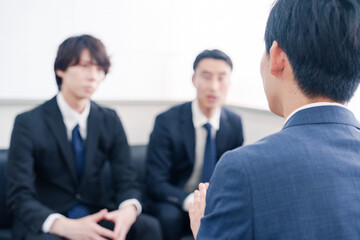 得意先と商談をするスーツを着たビジネスマン