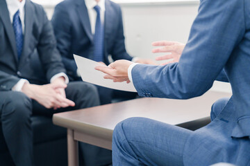 得意先と商談をするスーツを着たビジネスマン © maroke